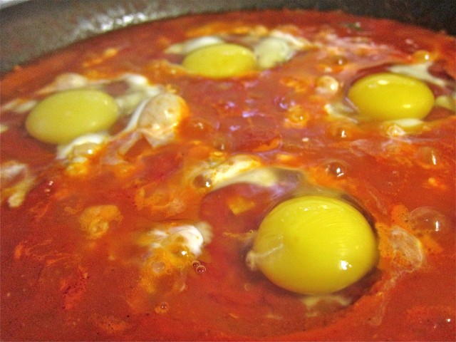 Crack eggs into shakshuka